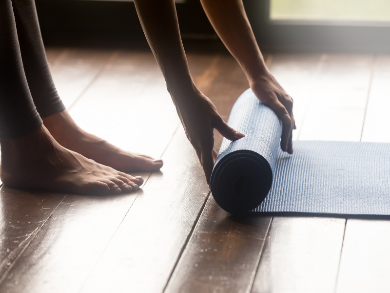 Beginning to roll out a yoga mat.