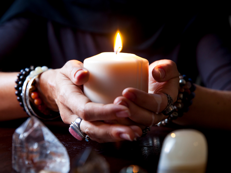 A lit candle held in cupped hands. A lit candle held in cupped hands.